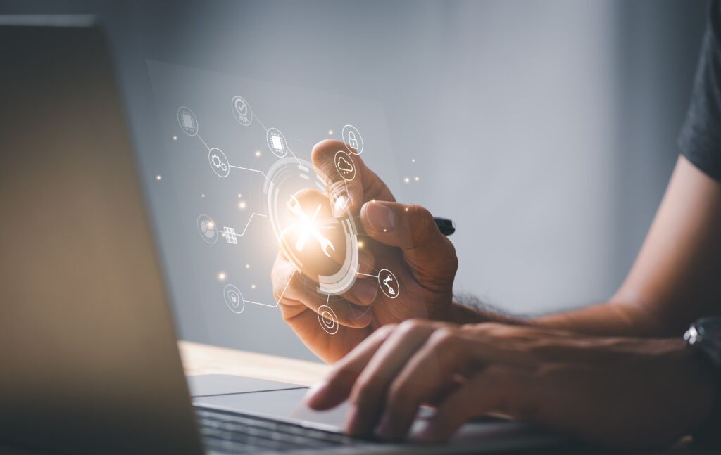 Hand op een toetsenbord met holografische pictogrammen die gegevens en digitale hulpmiddelen voorstellen.